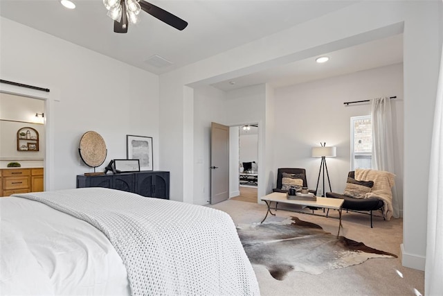 bedroom with a ceiling fan, ensuite bath, recessed lighting, and light carpet