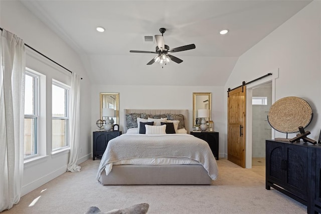 bedroom with baseboards, visible vents, vaulted ceiling, a barn door, and light colored carpet