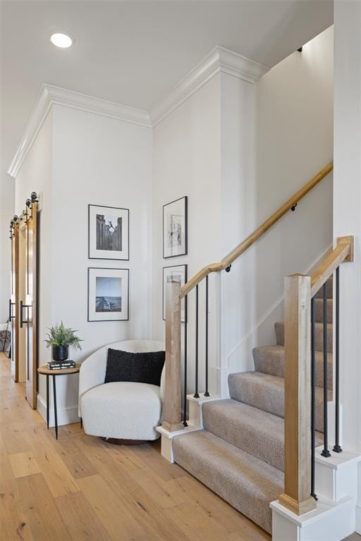 staircase featuring crown molding and wood finished floors