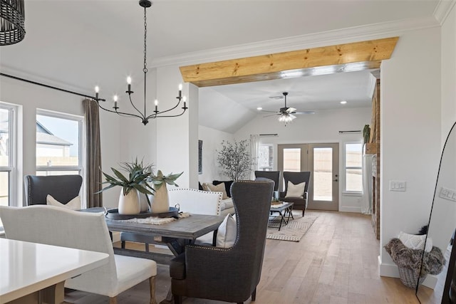 dining area with ceiling fan with notable chandelier, a healthy amount of sunlight, light wood-type flooring, and ornamental molding