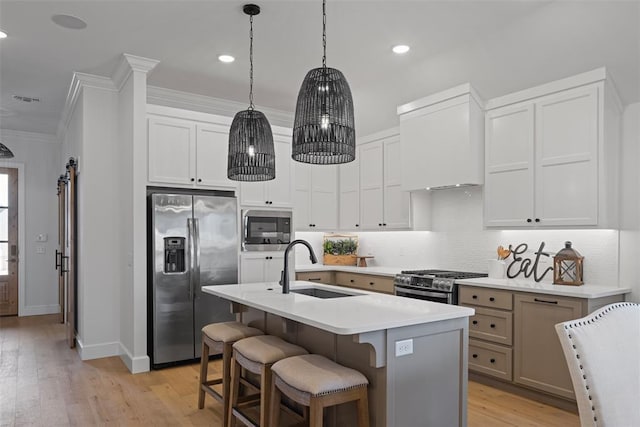 kitchen with backsplash, crown molding, light countertops, stainless steel appliances, and a sink