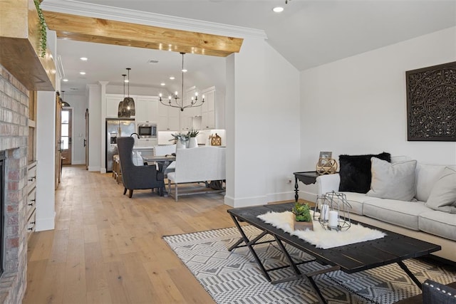 living room featuring a notable chandelier, crown molding, light wood-type flooring, and baseboards