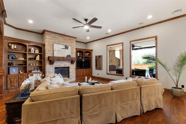 living area featuring wood finished floors, visible vents, a fireplace, ceiling fan, and crown molding