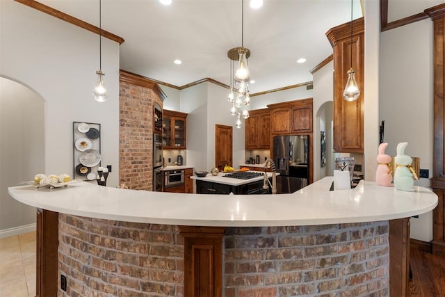 kitchen featuring light countertops, refrigerator with ice dispenser, arched walkways, and ornamental molding