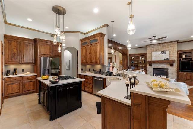 kitchen with light countertops, open floor plan, arched walkways, and stainless steel appliances