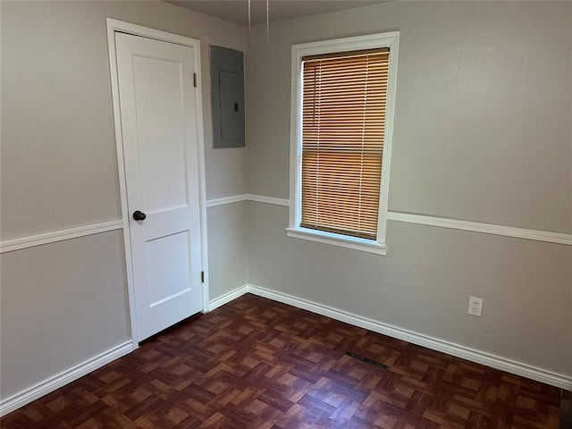 spare room featuring electric panel and baseboards