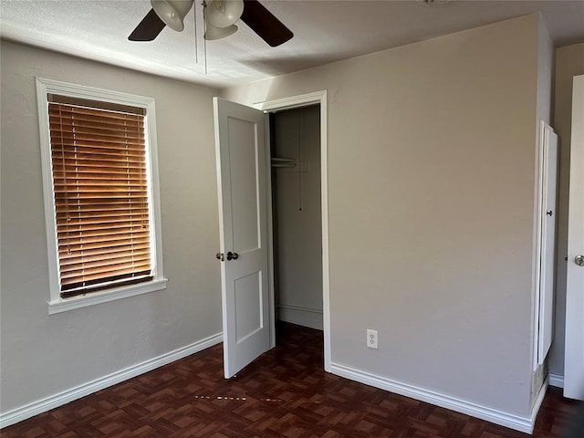 unfurnished bedroom with a ceiling fan, baseboards, and a closet