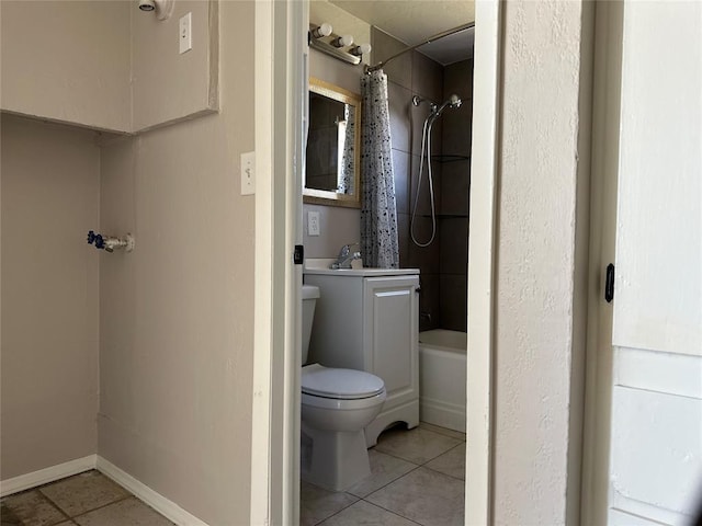 full bath with baseboards, toilet, shower / bath combo with shower curtain, tile patterned floors, and a sink