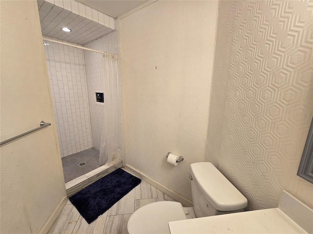 full bath featuring toilet, baseboards, and tiled shower