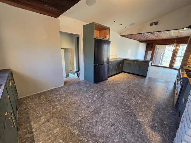 kitchen with visible vents, a peninsula, freestanding refrigerator, vaulted ceiling, and pendant lighting