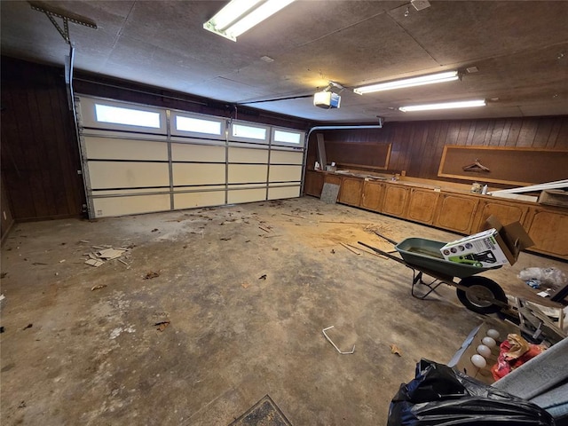 garage featuring wooden walls and a garage door opener