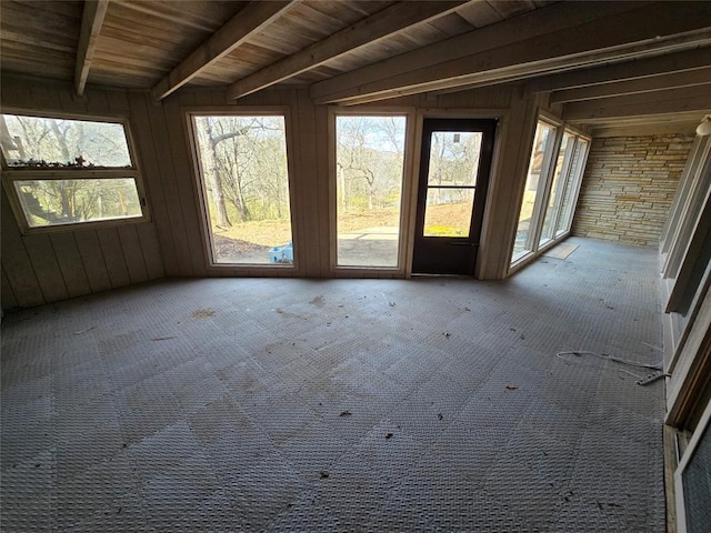 unfurnished sunroom featuring beam ceiling and wood ceiling