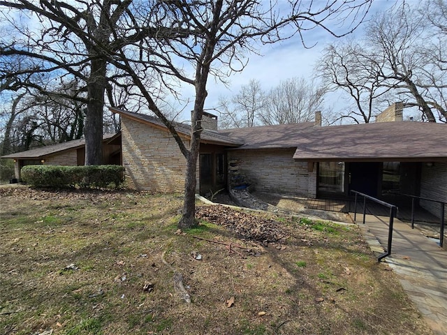 view of front of house featuring stone siding and a chimney