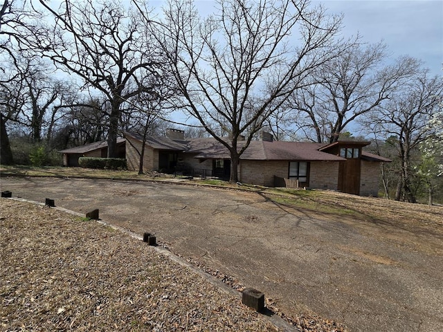 view of front facade featuring aphalt driveway and brick siding