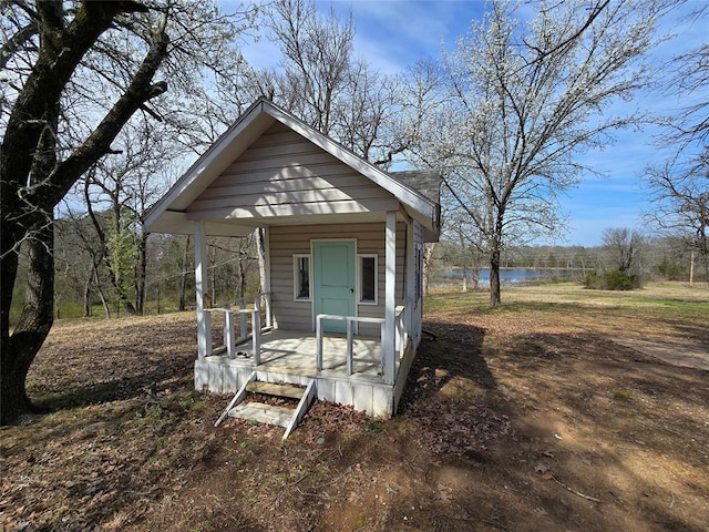 view of outbuilding featuring an outbuilding, covered porch, and a water view