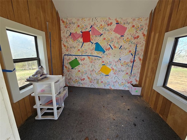 carpeted bedroom featuring wooden walls