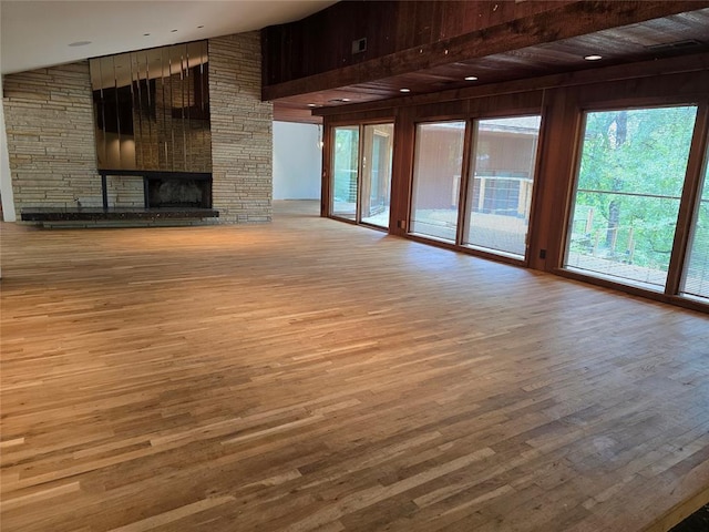 801 NE Ave C, Idabel, OK 74745 - unfurnished living room featuring wood finished floors, a fireplace, and wood walls