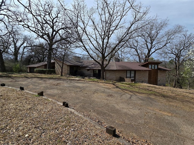 801 NE Ave C, Idabel, OK 74745 - mid-century modern home with a chimney and stone siding