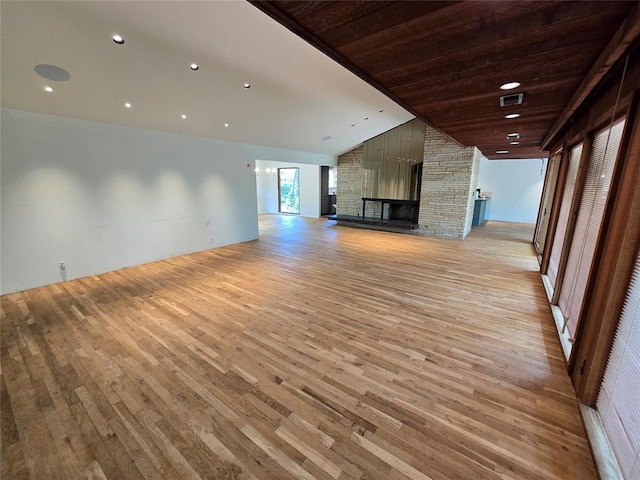 801 NE Ave C, Idabel, OK 74745 - unfurnished living room featuring light wood finished floors, lofted ceiling, a fireplace, and recessed lighting