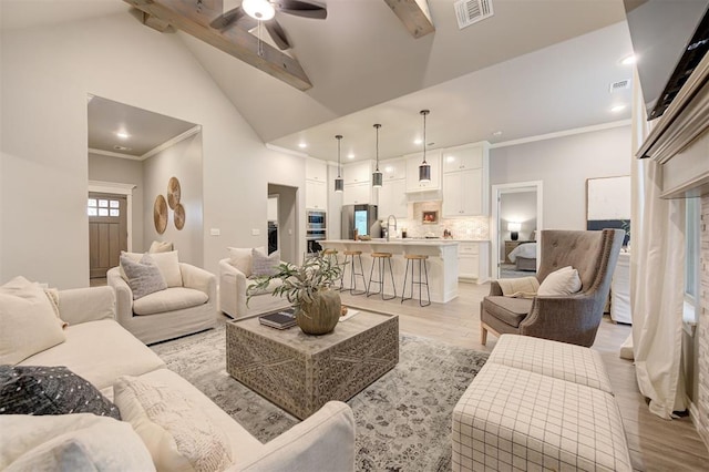 living area with visible vents, beam ceiling, high vaulted ceiling, a ceiling fan, and light wood finished floors