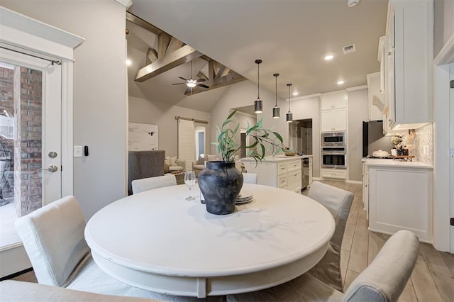 dining room featuring a ceiling fan, visible vents, light wood-style flooring, recessed lighting, and vaulted ceiling