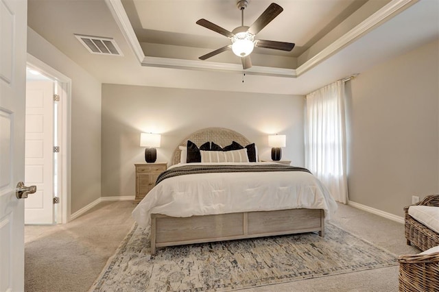 carpeted bedroom featuring visible vents, ceiling fan, baseboards, and a tray ceiling