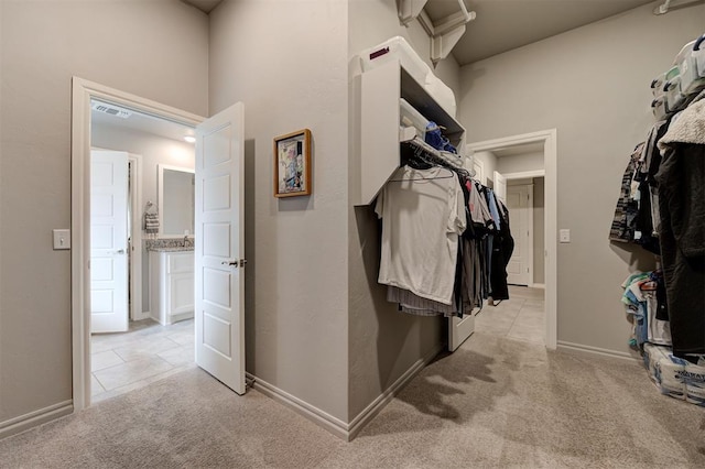 spacious closet featuring visible vents and light carpet