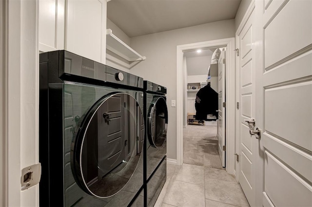 clothes washing area featuring washing machine and clothes dryer, laundry area, and light tile patterned floors