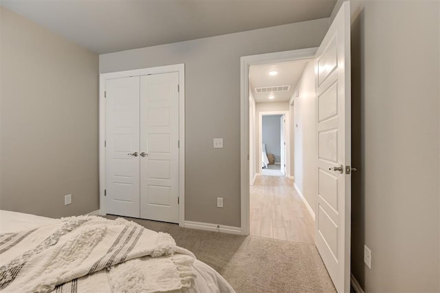 bedroom featuring a closet, visible vents, baseboards, and carpet