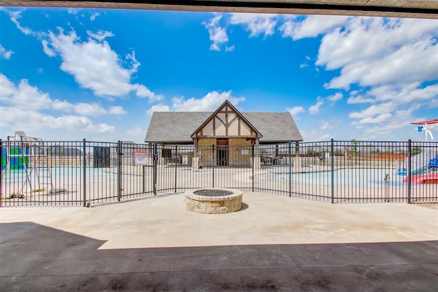 exterior space featuring a patio area, an outdoor fire pit, and fence