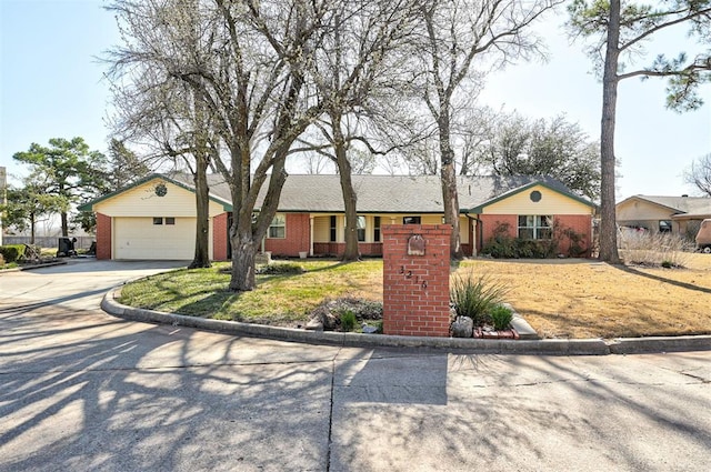 ranch-style house with a front yard, a garage, brick siding, and driveway