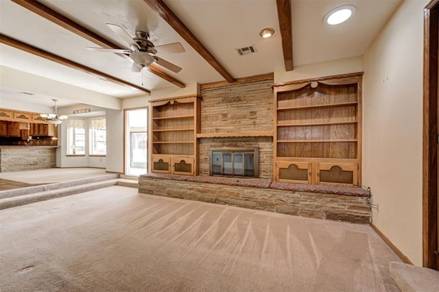 unfurnished living room featuring beamed ceiling, a fireplace, visible vents, and carpet floors