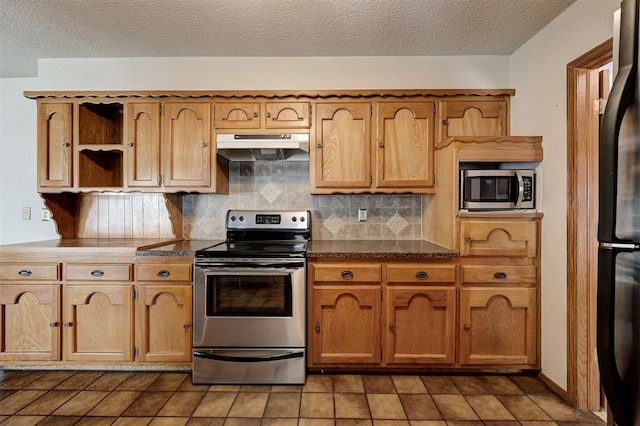 kitchen with open shelves, stainless steel appliances, under cabinet range hood, dark countertops, and tasteful backsplash