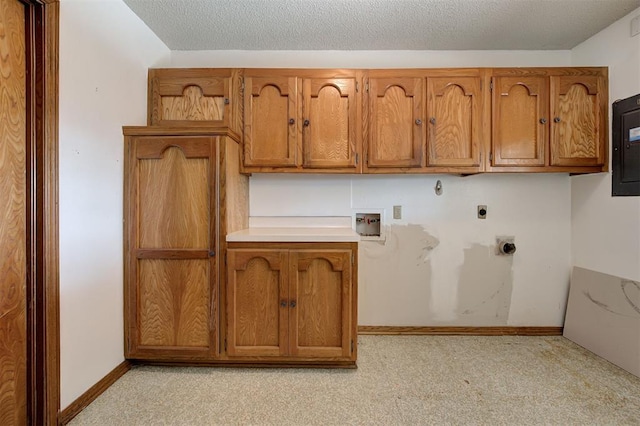 laundry area with baseboards, cabinet space, hookup for an electric dryer, and a textured ceiling