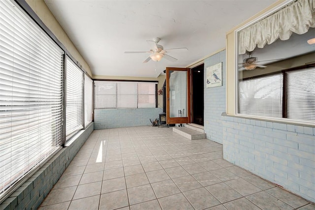 unfurnished sunroom with a ceiling fan