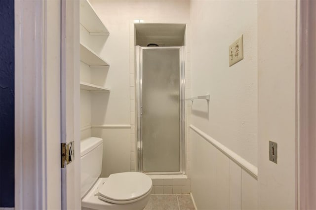 full bath with toilet, a shower stall, and tile patterned flooring