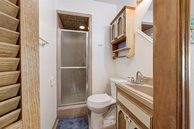 bathroom with a stall shower, toilet, and vanity