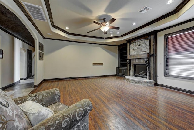 unfurnished living room with visible vents, a raised ceiling, ceiling fan, and wood finished floors