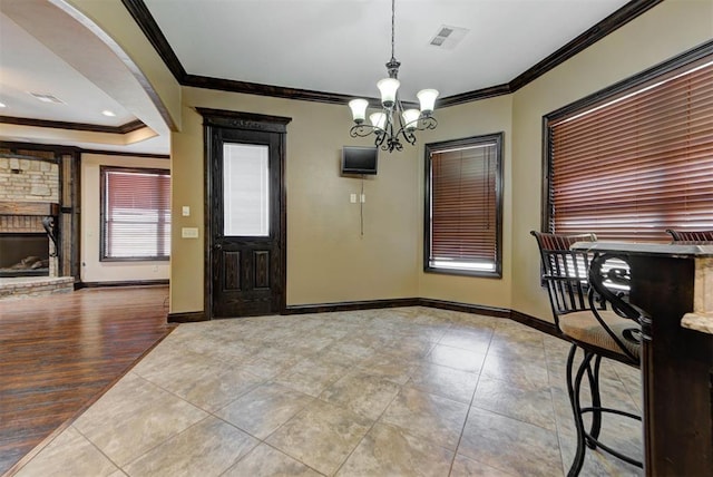 foyer with an inviting chandelier, baseboards, and ornamental molding