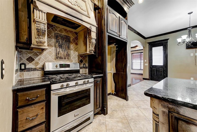 kitchen with backsplash, stainless steel range with gas cooktop, crown molding, light tile patterned floors, and hanging light fixtures