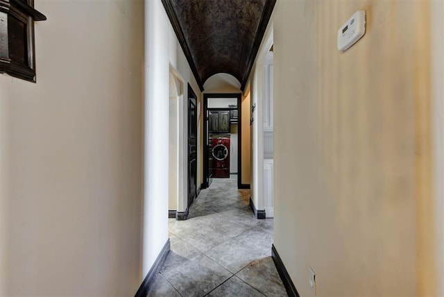 hallway featuring baseboards and washer / dryer