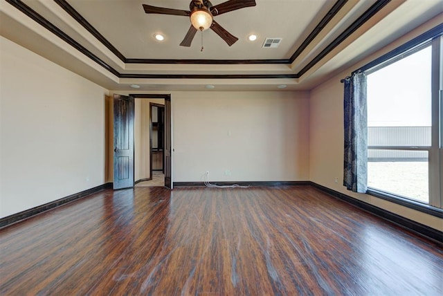 empty room featuring visible vents, ceiling fan, crown molding, and a tray ceiling