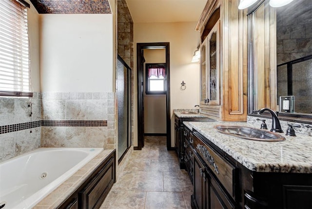 full bathroom featuring a shower stall, vanity, and a whirlpool tub