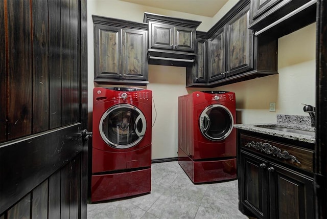 washroom featuring washing machine and clothes dryer, cabinet space, and a sink