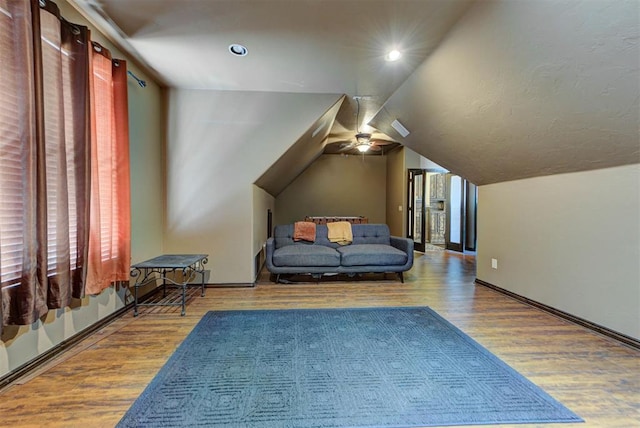 sitting room featuring baseboards, lofted ceiling, ceiling fan, and wood finished floors