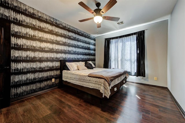 bedroom with visible vents, baseboards, wood finished floors, and a ceiling fan