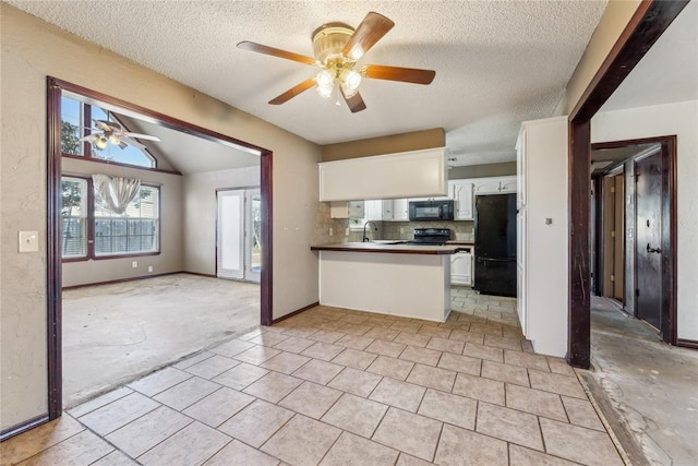 kitchen featuring open floor plan, white cabinets, a peninsula, and black appliances