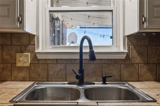 details featuring backsplash, light countertops, and a sink