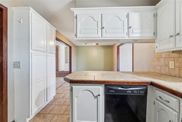 kitchen with light tile patterned floors, a peninsula, decorative backsplash, white cabinets, and dishwasher