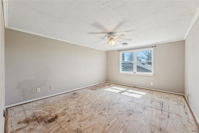 spare room featuring crown molding, a ceiling fan, visible vents, and baseboards